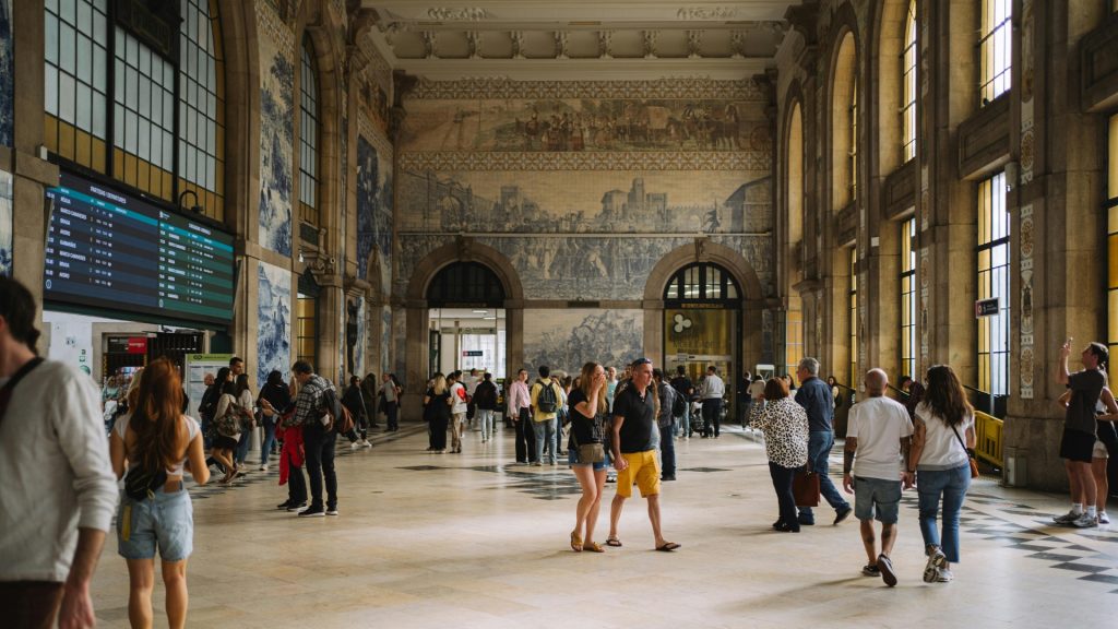 São Bento Railway Station interior with iconic blue azulejo tile murals depicting Portuguese history.