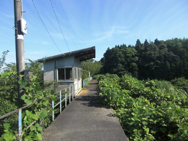 Deserted Ushima Station platform on Japan’s abandoned Noto railway line, showing weathered signs and quiet rural tracks.