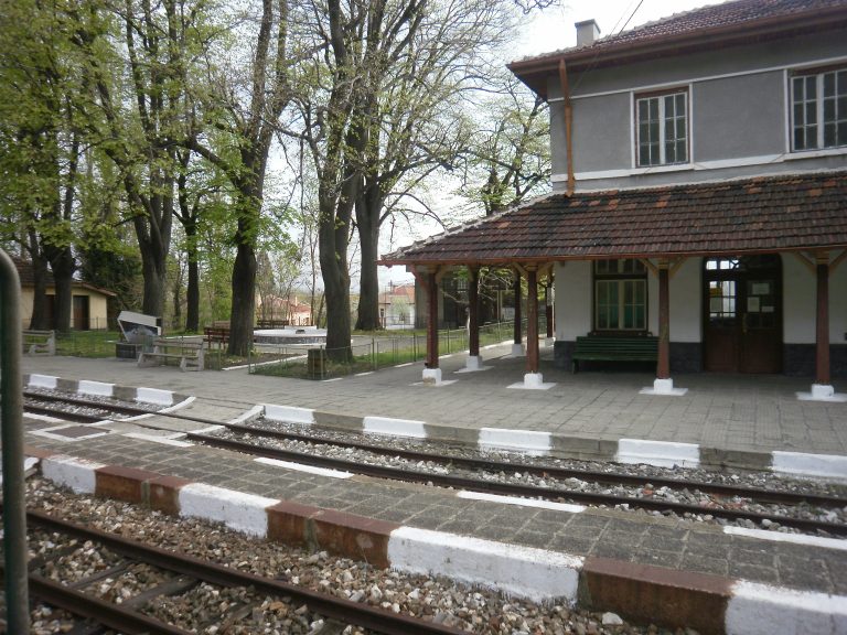 Old Varvara Railway Station in Bulgaria with empty platform, peeling paint, and unused railway tracks.