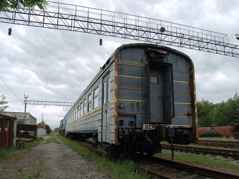 Abandoned Yaniv Railway Station in the Chernobyl Exclusion Zone with overgrown tracks and derelict buildings.